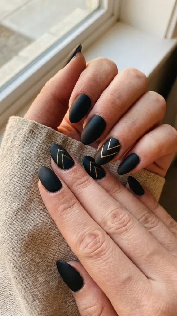 black almond nails with gold accents